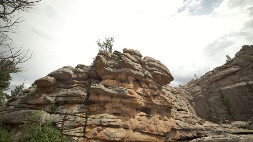 Tilt down slider shot of unique rock formations and driftwood at Gem Lake in Rocky Mountain National Park.