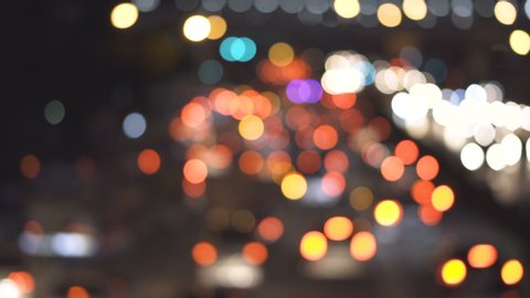 Beautiful colourful round bokeh of car headlight on road at night,Defocus moving glittering light on Bangkok city street