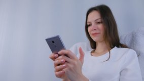 Woman watches funny video on mobile phone