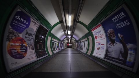 LONDON, ENGLAND - SEPTEMBER 10, 2019:  Tunnel path for commuters and city workers in London tube underground subway train station. Concept of English modern urban life, city lifestyle in England.