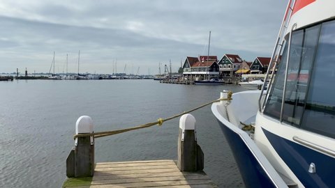 Volendam,Netherlands-October 7,2019:Tourist ferry parked by pier in bay.Volendam is a town in North Holland.Sometimes called The pearl of the Zuiderzee, this place is a highly popular tourist destinat