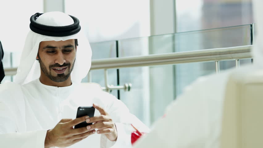 Arab male kandura touch screen smart phone social leisure hotel travel lifestyle