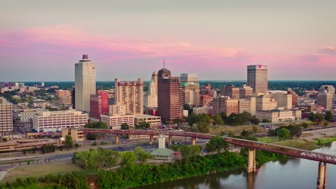 MEMPHIS, TENNESSEE / USA - OCT 9 2019: Aerial drone footage of downtown Memphis framed against a pink sky near sunset, with traffic along Riverside Drive and from the Bass Pro Shops at the Pyramid. 4k