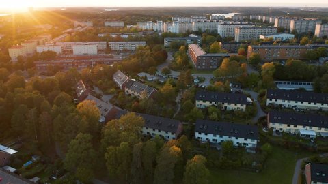 Drone pans over Stockholm suburb during beautiful sunset. Aerial view of houses, Sweden.