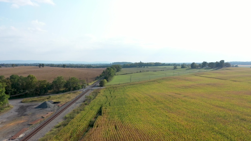 Pull back and descending aerial view of cornfields to reveal old train station in Charlestown, West Virginia.