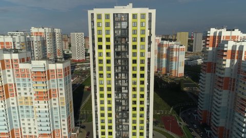 Aerial close in front of windows modern dormitory area houses buildings new real estate architecture sleeping quarters. Comfortable houses Moscow Russia outskirts design development. Sunny blue sky
