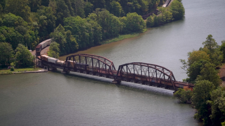 Empty cargo train cars going over a bridge on the New River in West Virginia.
