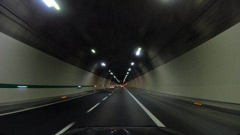 Road trip on highway, first-person view of a moving car, ride inside the tunnel under the mountain.