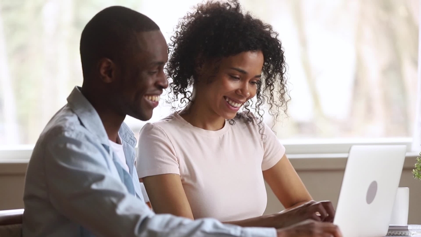 Black couple read e-mail on laptop screaming with happiness by amazing news feels overflowing emotions got opportunity to work, dream came true, bank approved loan for purchase of new housing concept Royalty-Free Stock Footage #1038796247