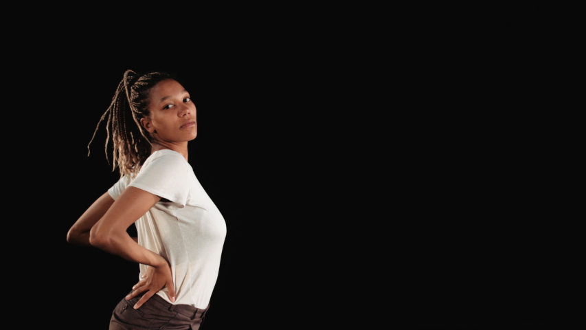 Black woman dancing on black isolated background. Three quarter length.