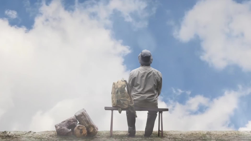 Photo of a male traveller with backpack sitting on a bench on a sunny day with fluffy clouds.