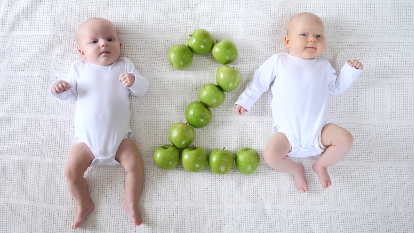 Cute Twin Two Months Babies In White Bodysuites