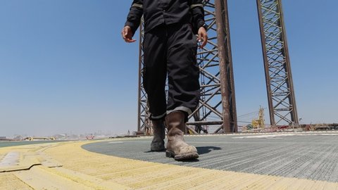 Worker walks in the helideck of a jack up drilling rig
