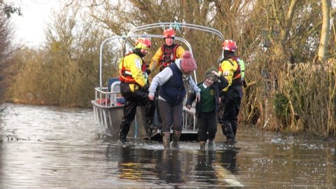 Muchelney / United Kingdom (UK) - 02 11 2014: Firefighters help residents disembark from flood ferry