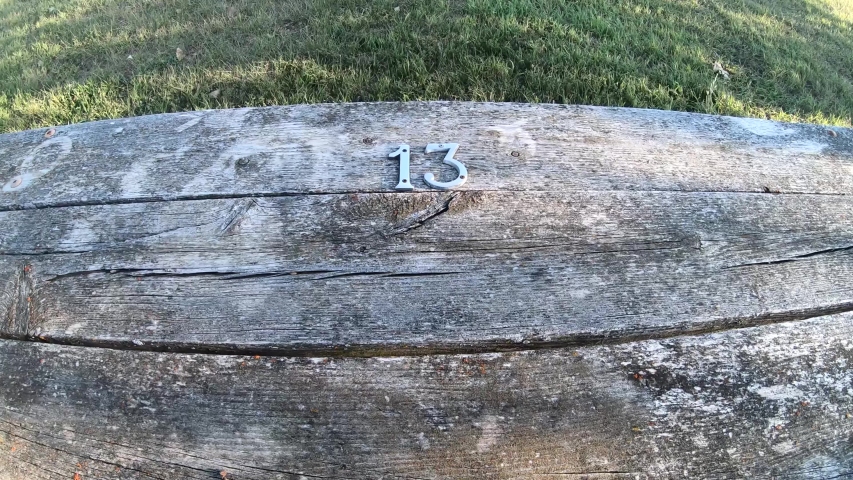 Wooden bench in the park with the number 13 on it.