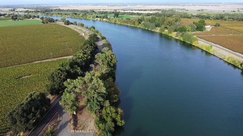 Aerial view of the Sacramento River winding through vineyards in California's Central Valley.