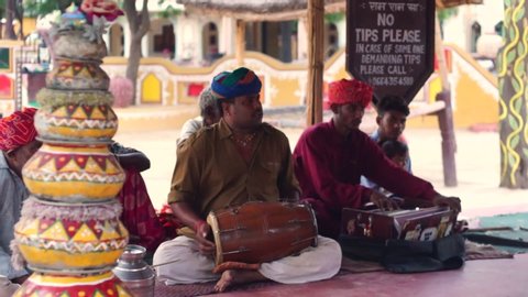 Jaipur, Rajasthan, India, asia - circa 2019 : Traditional rajasthani musicians sitting on the floor and playing a dholak and harmonium as part of a dance performance. Shows a traditional style of