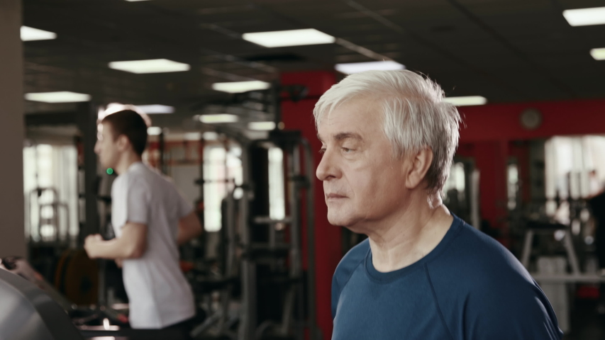 Physical Exercises and Sport Work Out at Gym Room. 50s or 60s Elderly Man Training Healthy Body Close Up. Workout of Old People for Athlete Muscles Inside Fitness Hall. Session of Physical Activity Royalty-Free Stock Footage #1038847325