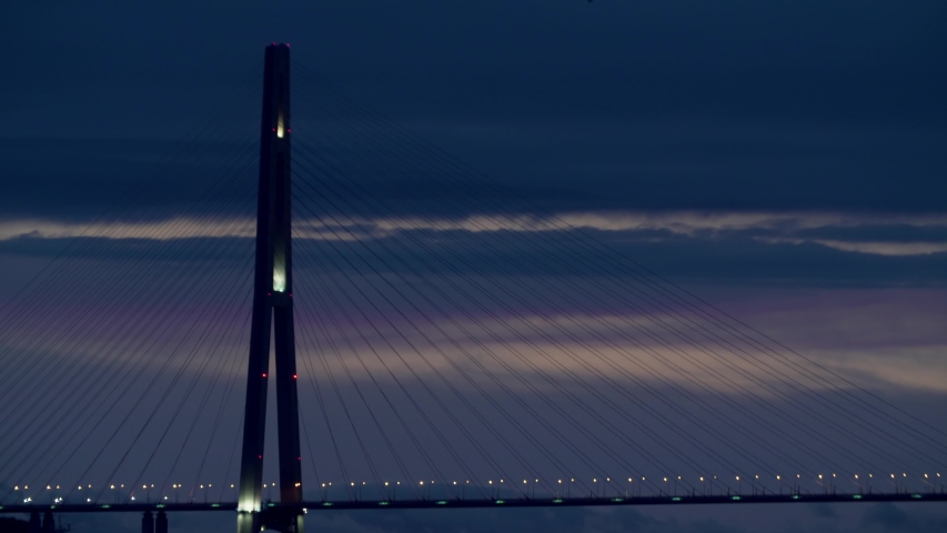 Static view of Russian bridge with warning lights blinking on it. Predawn hours, wonderful sky. Vladivostok, Russia
