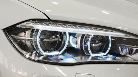 Moscow, Russia - May, 2019: Head light of BMW X6M F86 with raindrops on close up overview