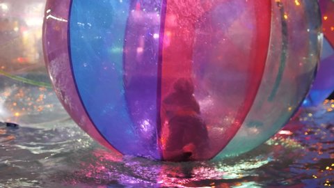 Russia, Anapa, August 4, 2019. Children play and fun in the pool inside large multi-colored plastic balls on the water.