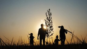 happy family walking agriculture of farmers a silhouette concept slow motion video. mom dad son and daughter walk go children plant and water the tree outdoors lifestyle in the park. happy family