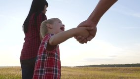 happy family little boy a holds parents hand walking go slow motion video concept. happy teamwork dad man mom girl and son boy child hold hands walk go on field in nature lifestyle .happy family