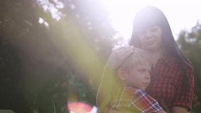 happy family mom and son lifestyle concept .mom tender childhood video . slow a motion video.mom brunette girl gently hugs takes care of the boy son blonde outdoors