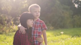happyfamily mother's day the nature slow motion video teamwork outdoors . son boy hugs mom girl lifestyle outdoors shows the distance with his hand sunlight cute video care. mother and son cuddle