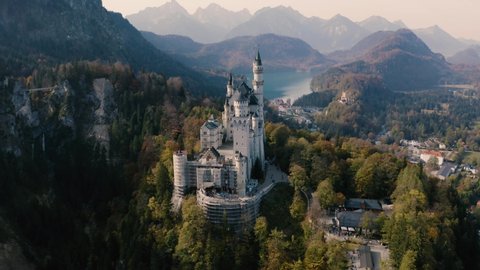 Neuschwanstein Castle Autumn Landscape in Bavaria, Germany | 4K UHD D-LOG -Perfect for colour grading! Fall colours over trees in The Alps, featuring a cinematic drone shot of the fairytale castle.