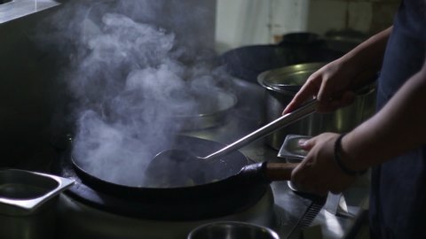 Chinesse food. Working chef preparing chinese food, Food frying in wok pan. Close up. Food concept. Slow motion.