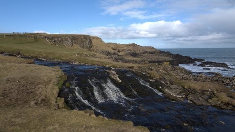 Waterfall and headland at Dunseverick Castle, Co Antrim, Northern Ireland