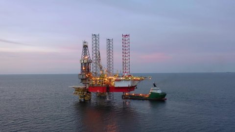 SARAWAK, MALAYSIA - OCTOBER 12, 2019: Standby vessel nearby Velesto Naga 7 offshore jack-up drilling rig in Malaysian Waters with beautiful sunset sky.