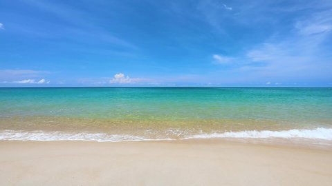 Phuket tropical beach on high season in Thailand. The waves on sand beach and beautiful sky.