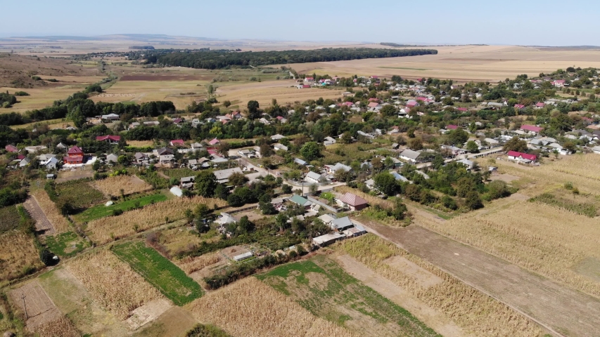 Aerial view of a rural area comprising of houses and cornfields on a sunny day
