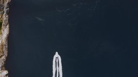 Boat sailing through Saltstraumen strait in Norway Top down drone aerial view video from above