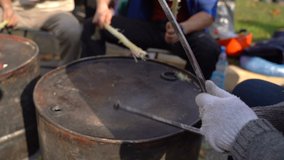 Workers stick on an iron barrel for protests. Slow motion. Video with sound