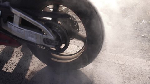 a sports bike makes smoke and the wheel rotates in one place