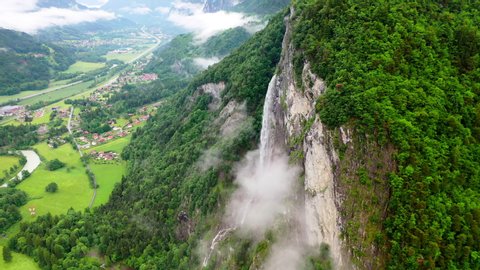 Aerial Circling: Thin Waterfall Among Lush Green on Stunning Mountain over Picturesque Town - Chamonix, France