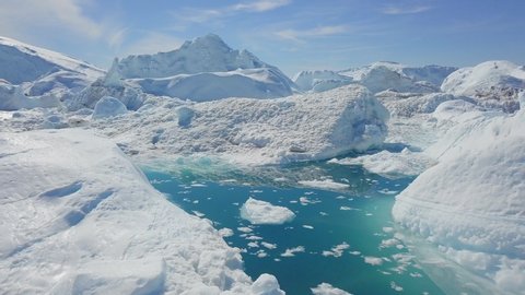 Aerial Forward: Bright Blue Pond in Amazing Icefield on a Sunny Day, Disko Bay, Greenland: stockvideo