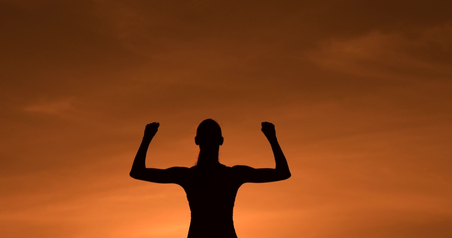 Strong woman, Winning, success , and life goals concept. Young woman silhouette flexing arms facing the sunset. 
 Royalty-Free Stock Footage #1038936488