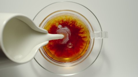 SLOW MOTION: Adding Milk From Milk Jug Into A Cup Of Black Tea