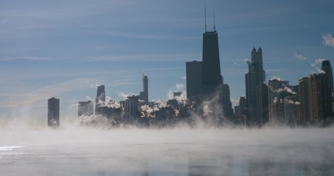Downtown Chicago skyline during winter polar vortex. Close up view of fast drifting fog above Lake Michigan
