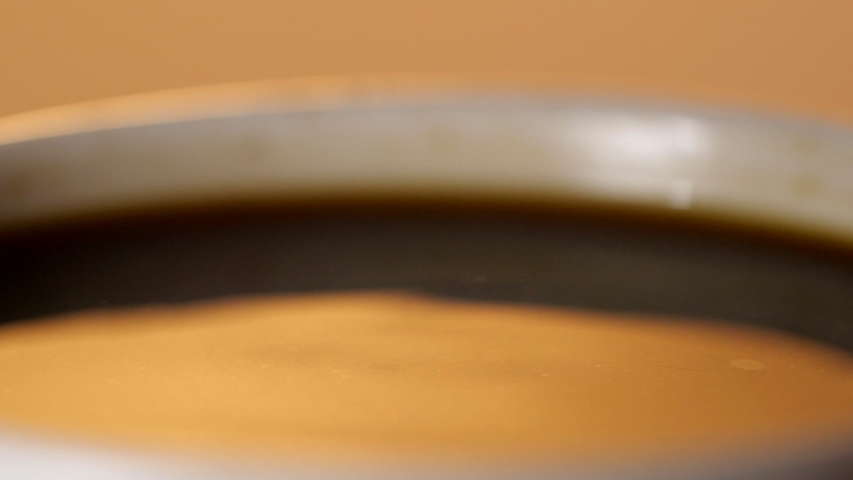 Black coffee drop into the filled Cup from the coffee machine in slow motion Royalty-Free Stock Footage #1038940523
