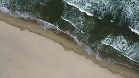 Aerial view with rotation of the turquoise water of Black Sea, above waves and sand, Bulgaria.  