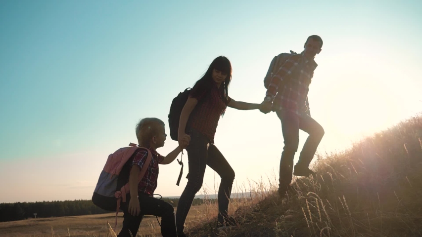 Teamwork hikers help business travel silhouette concept. group of tourists happy family lends a helping hand climb the cliffs mountains. people mom dad and son little boy climbers teamwork climb to | Shutterstock HD Video #1038944732