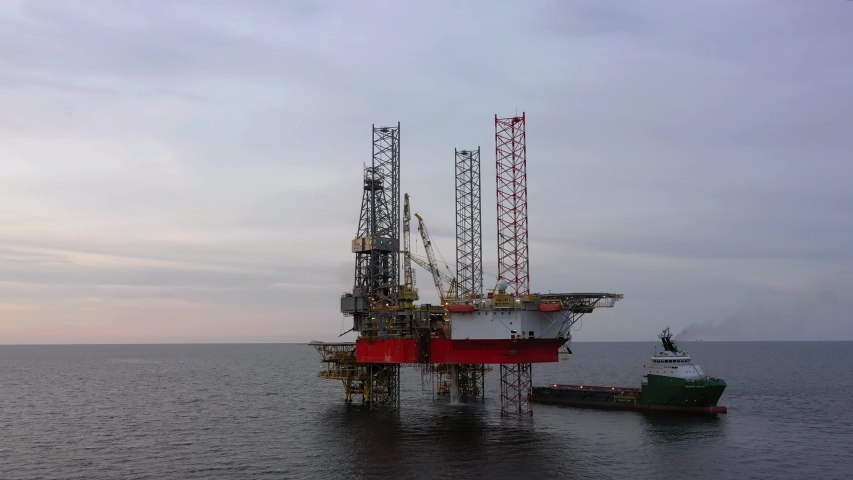 SARAWAK, MALAYSIA - OCTOBER 12, 2019: Standby vessel nearby Velesto Naga 7 offshore jack-up drilling rig in Malaysian Waters with beautiful sunset sky. | Shutterstock HD Video #1038947387