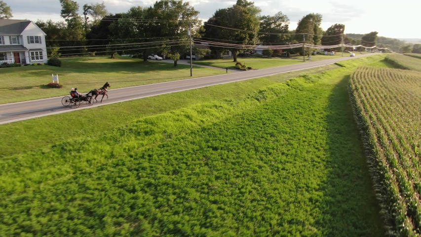 A young Amish couple courting in open air horse and buggy carriage, aerial view, Lancaster, Pennsylvania