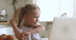 Curious cute little kid girl using laptop alone, smart preschool child learning computer online surfing internet without parental control at home, children education technology addiction concept