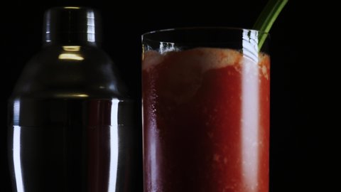 A red bloody mary drink cocktail isolated against black background